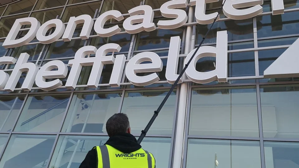 Wrights Cleaning operative in branded hi-vis cleaning airport glazing