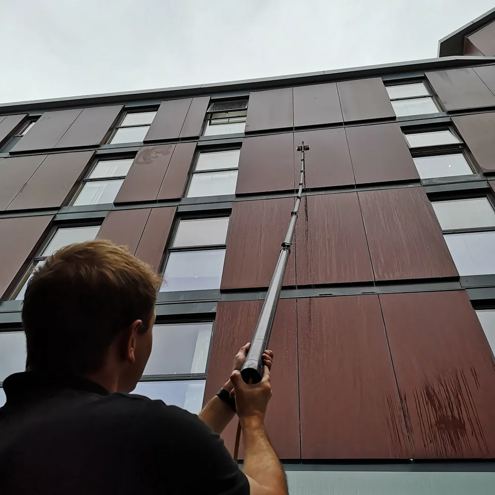 Water-fed pole reaching the upper-floor windows of an apartment block