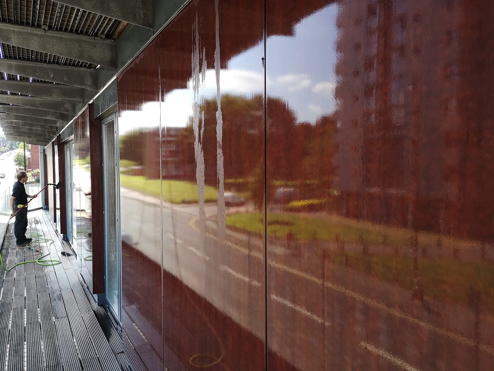 Operative cleaning glazing along an apartment block walkway