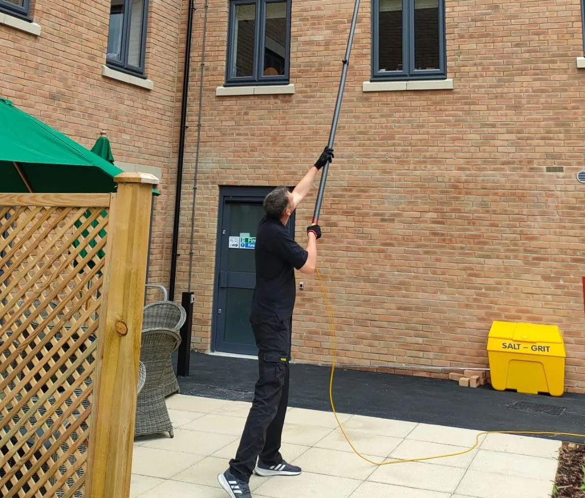 Operative cleaning the upper windows of an apartment block from its courtyard