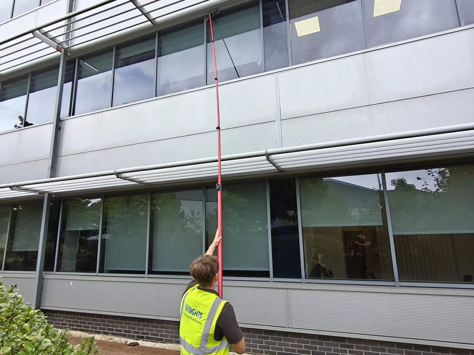 Commercial window cleaning in Barnsley: an operative reaching first-floor office windows with a water-fed pole