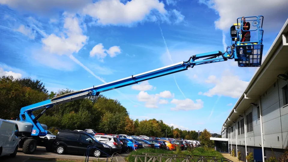 Cherry picker extended over a business park to reach high-level glazing