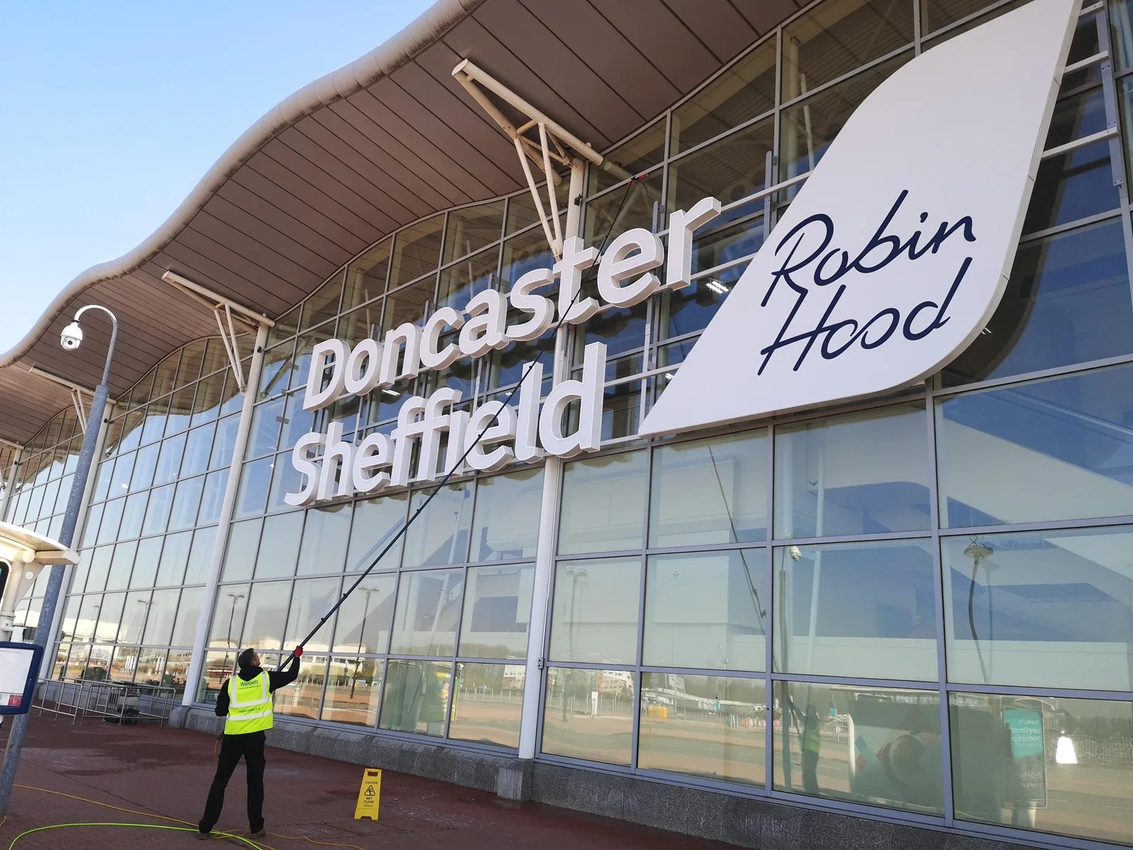 Commercial window cleaning in Doncaster: a water-fed pole cleaning the glass frontage of Doncaster Sheffield Airport