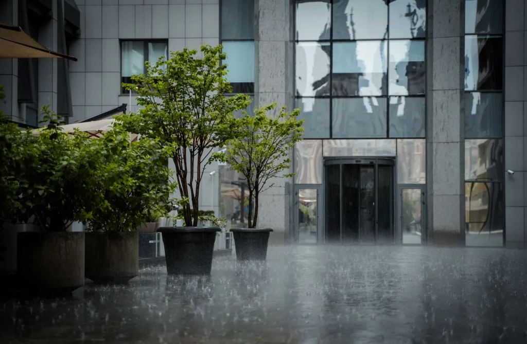Heavy rain bouncing off the paving outside an office building entrance