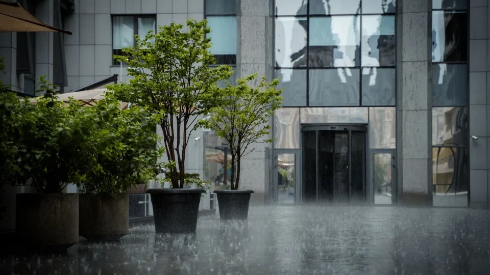 Heavy rain bouncing off the paving outside an office building entrance