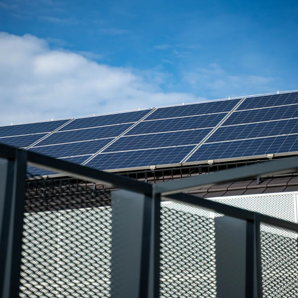 Solar panels on the roof of a commercial building against a blue sky