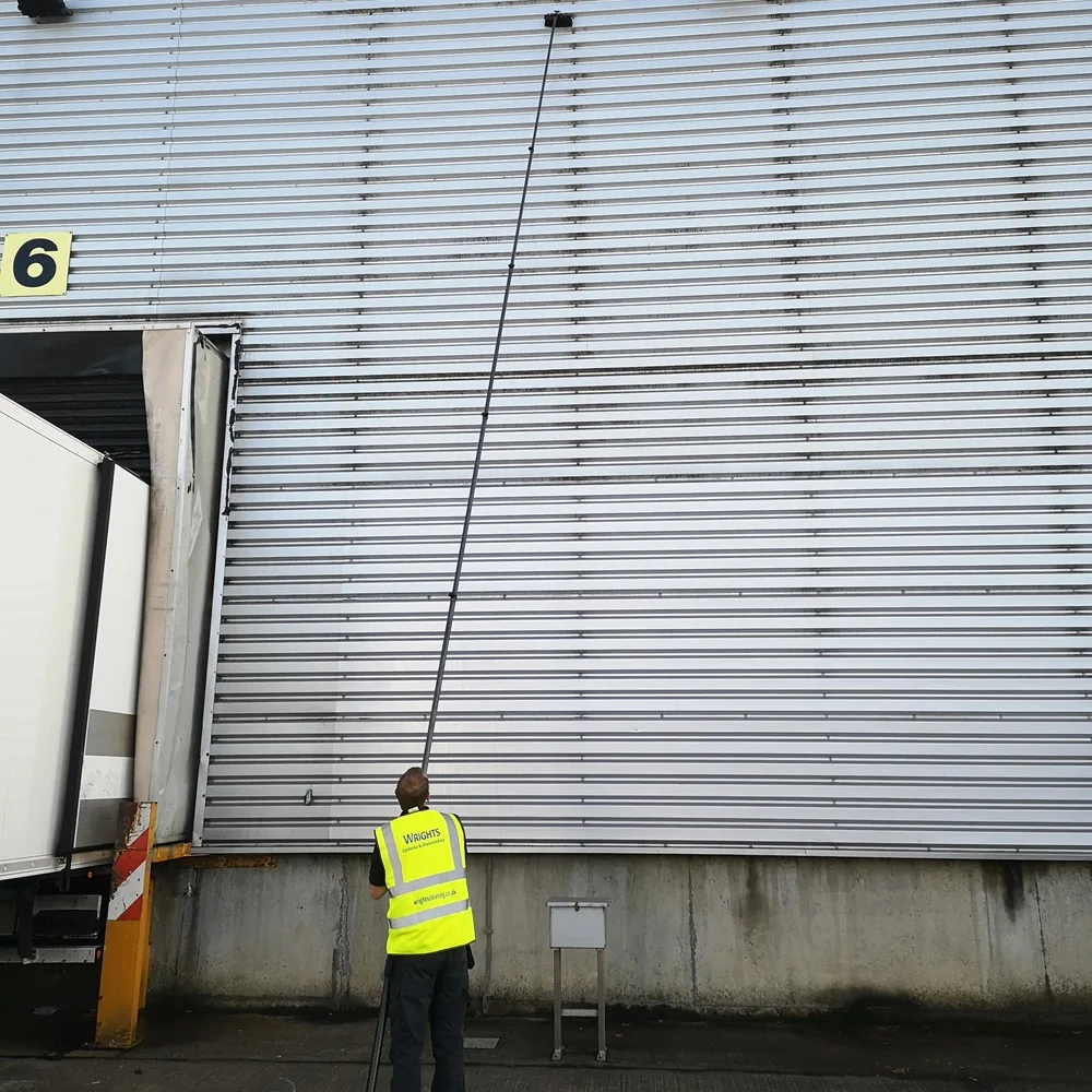Water-fed pole reaching the top of a warehouse wall